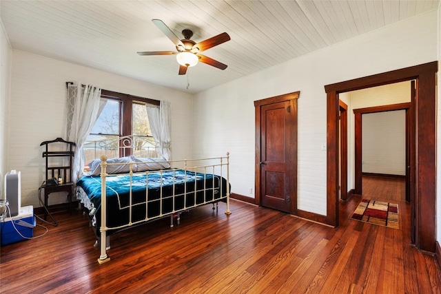 117 N Main St, Paige, TX 78659 - bedroom with wood finished floors, baseboards, and a ceiling fan
