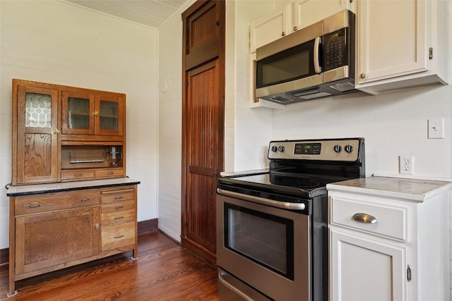 117 N Main St, Paige, TX 78659 - kitchen featuring stainless steel appliances, dark wood-style floors, glass insert cabinets, and white cabinetry