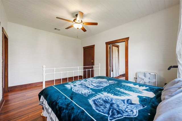 117 N Main St, Paige, TX 78659 - bedroom featuring wood-type flooring, a ceiling fan, and baseboards
