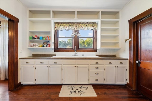 117 N Main St, Paige, TX 78659 - kitchen featuring open shelves, white cabinetry, dark wood finished floors, built in shelves, and a sink