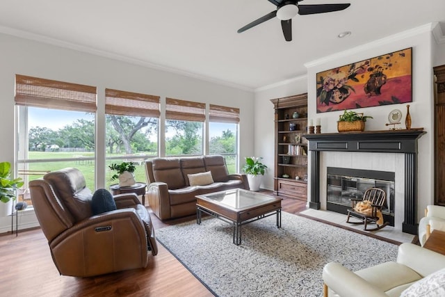420 Oak Forest Dr, Buda, TX 78610 - living area with plenty of natural light, crown molding, ceiling fan, a tile fireplace, and wood finished floors