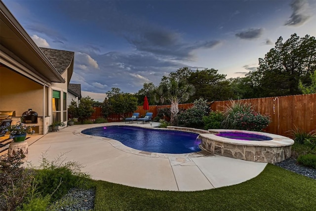 view of pool featuring a fenced backyard, a patio, and a pool with connected hot tub