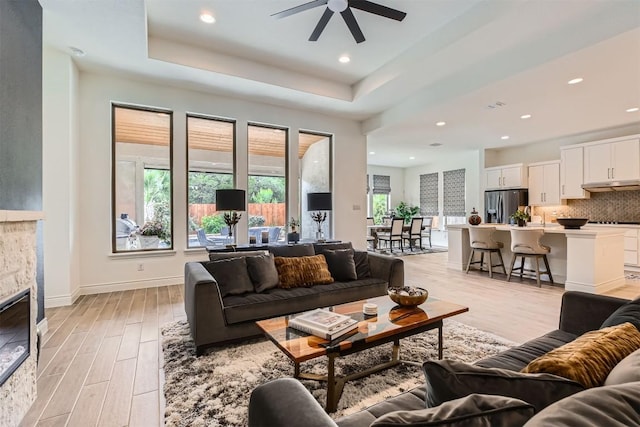 25727 Madison Rnch, San Antonio, TX 78255 - living area with light wood-style floors, ceiling fan, a raised ceiling, recessed lighting, and baseboards