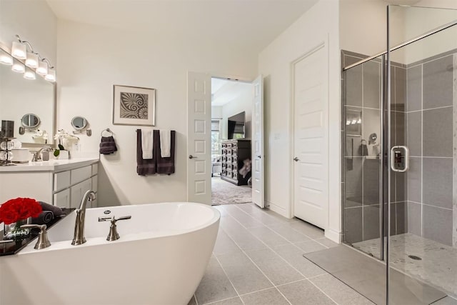 ensuite bathroom featuring a shower stall, a soaking tub, vanity, and tile patterned flooring