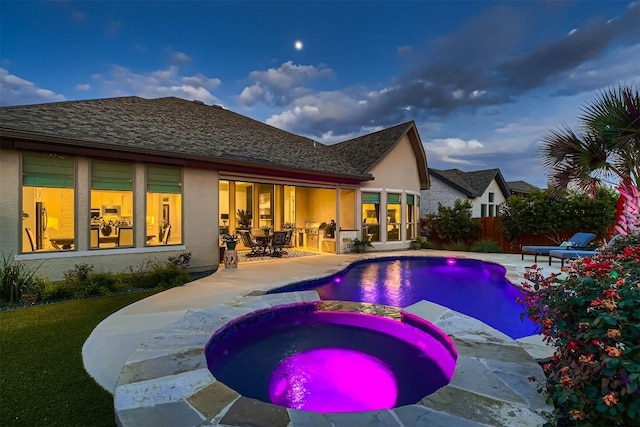 view of swimming pool with a patio, fence, and a pool with connected hot tub