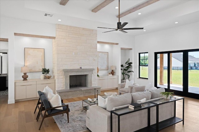 1754 County Road 146th Rd, Georgetown, TX 78633 - living area featuring light wood-style floors, beamed ceiling, a ceiling fan, a fireplace, and a towering ceiling
