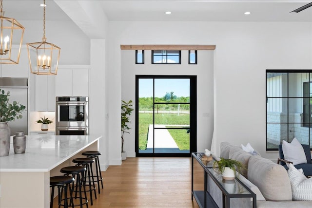 1754 County Road 146th Rd, Georgetown, TX 78633 - living area with light wood-style flooring, a chandelier, recessed lighting, and a towering ceiling