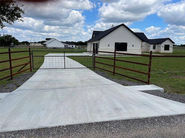 1754 County Road 146th Rd, Georgetown, TX 78633 - view of side of property with a gate, board and batten siding, and concrete driveway