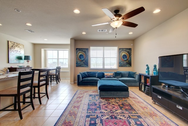 living area with light tile patterned floors, ceiling fan, recessed lighting, and baseboards