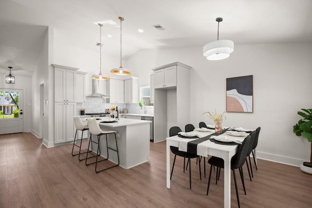 1417 Charolais Dr, Austin, TX 78758 - kitchen featuring backsplash, wall chimney range hood, light countertops, a kitchen island, and wood finished floors