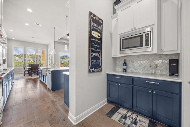2032 Murano Ln, Leander, TX 78641 - kitchen with stainless steel appliances, blue cabinetry, light wood-style flooring, light countertops, and white cabinets