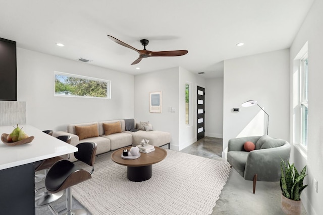 living room with a ceiling fan, recessed lighting, baseboards, and finished concrete flooring