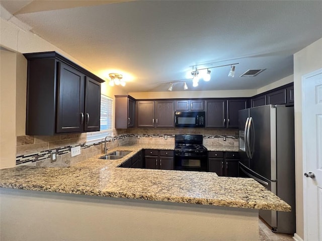 kitchen with black appliances, a sink, light stone counters, and tasteful backsplash