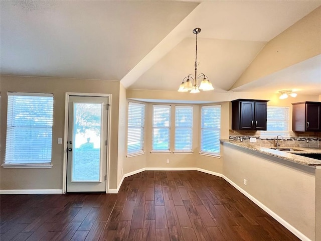 entryway with a chandelier, dark wood-type flooring, lofted ceiling, plenty of natural light, and a sink