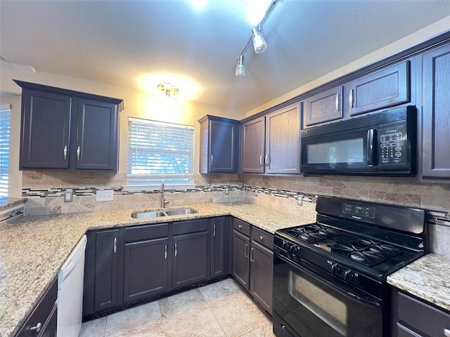kitchen with black appliances, a sink, tasteful backsplash, and light stone countertops