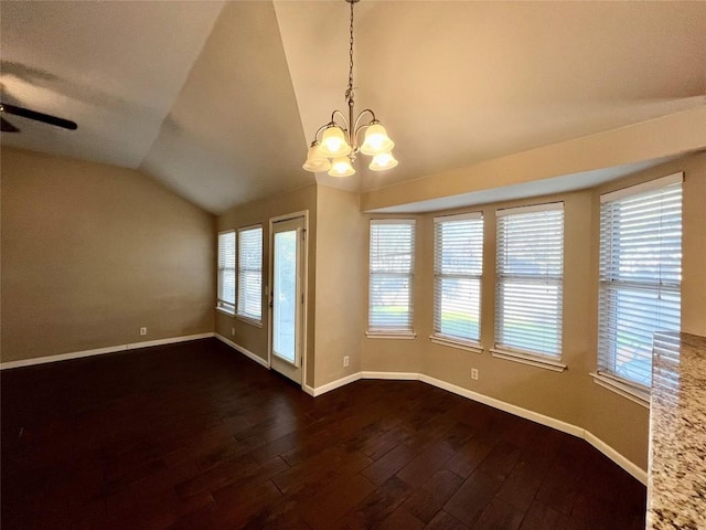 unfurnished dining area with vaulted ceiling, dark wood-style flooring, baseboards, a chandelier, and ceiling fan