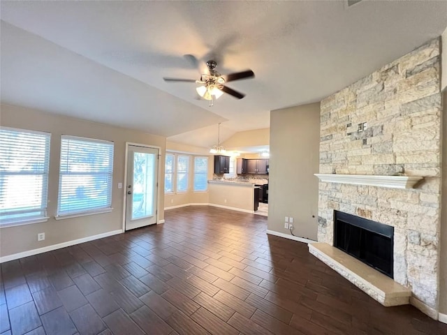 unfurnished living room featuring ceiling fan, lofted ceiling, plenty of natural light, a fireplace, and dark wood finished floors