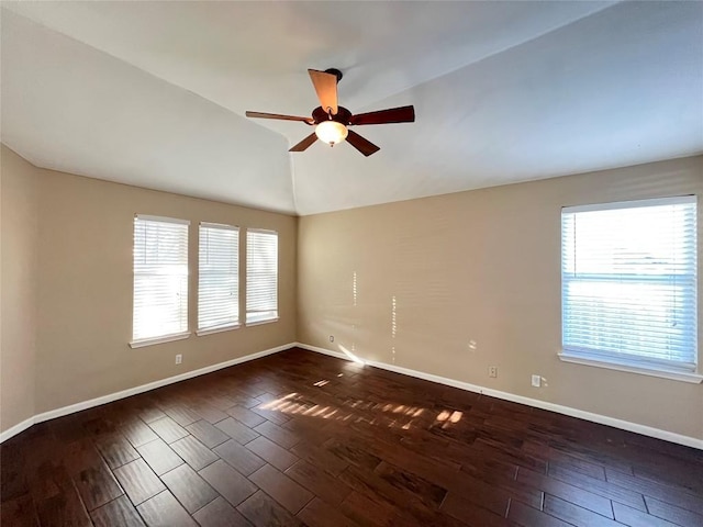 empty room featuring ceiling fan, dark wood-style floors, baseboards, and lofted ceiling