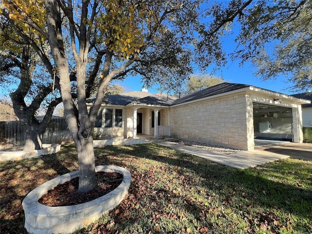 ranch-style home with an attached garage and stone siding