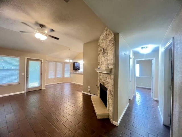 1800 Columbine Ln, Leander, TX 78641 - unfurnished living room with ceiling fan, lofted ceiling, a stone fireplace, plenty of natural light, and a chandelier
