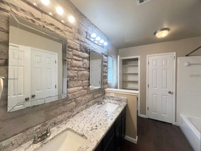 bathroom with double vanity, wood finished floors, and  shower combination
