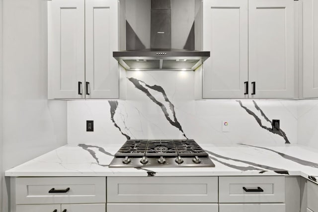1111 Walton Ln Unit 2, Austin, TX 78721 - kitchen featuring wall chimney exhaust hood, stainless steel gas cooktop, backsplash, and light stone counters