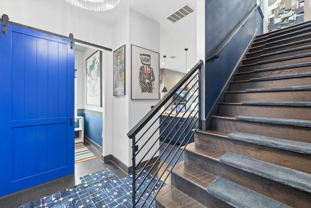 1111 Walton Ln Unit 2, Austin, TX 78721 - staircase with a barn door, wood finished floors, and baseboards