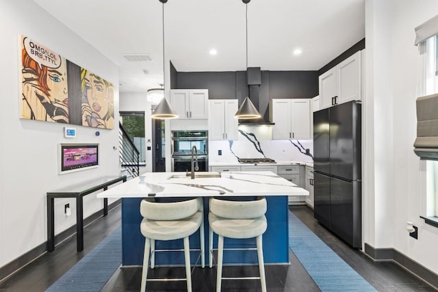 1111 Walton Ln Unit 2, Austin, TX 78721 - kitchen featuring freestanding refrigerator, stainless steel double oven, wall chimney range hood, gas stovetop, and a sink