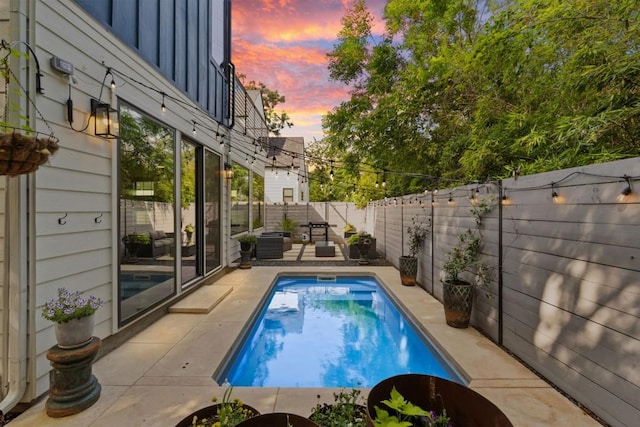 1111 Walton Ln Unit 2, Austin, TX 78721 - pool at dusk featuring a patio and a fenced backyard