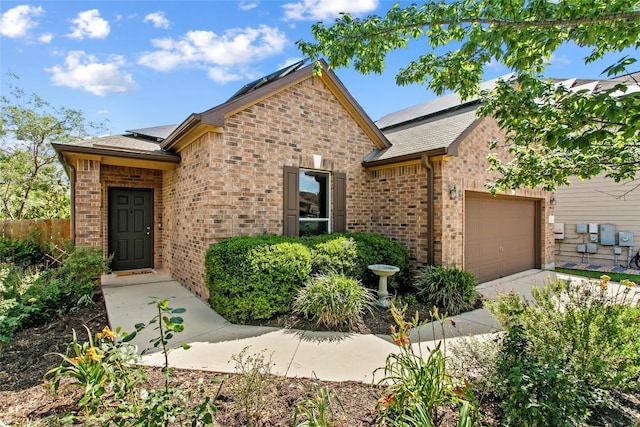 6212 Bumpstead Dr, Austin, TX 78747 - view of front of property featuring brick siding, a garage, solar panels, and concrete driveway