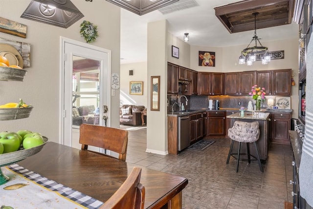 401 Southern Dr, Buda, TX 78610 - kitchen featuring dishwasher, a sink, tile patterned flooring, backsplash, and a center island