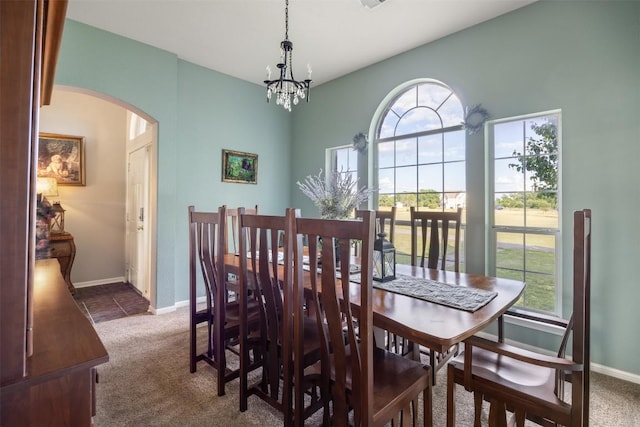 401 Southern Dr, Buda, TX 78610 - dining room featuring arched walkways, dark colored carpet, healthy amount of natural light, and a chandelier