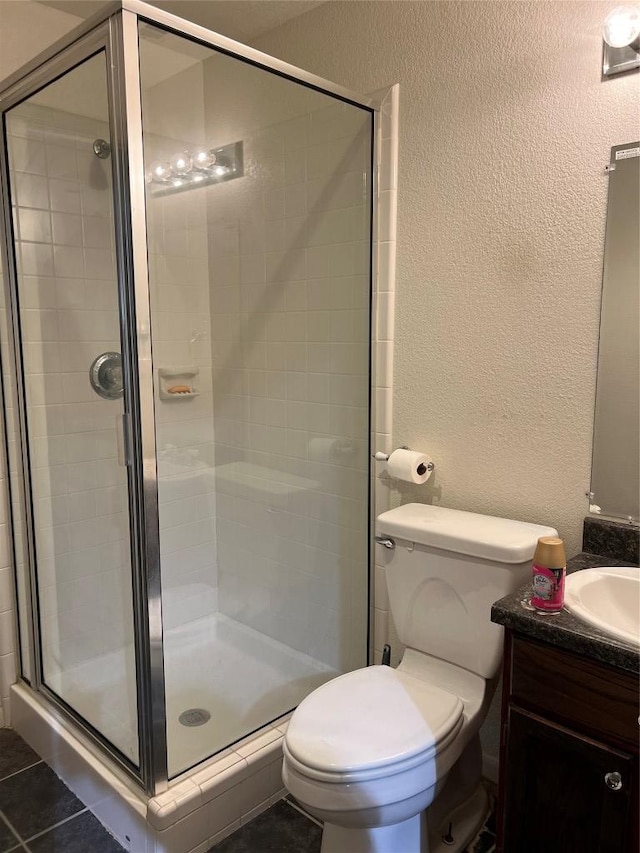 401 Southern Dr, Buda, TX 78610 - bathroom with a textured wall, a shower stall, toilet, and vanity