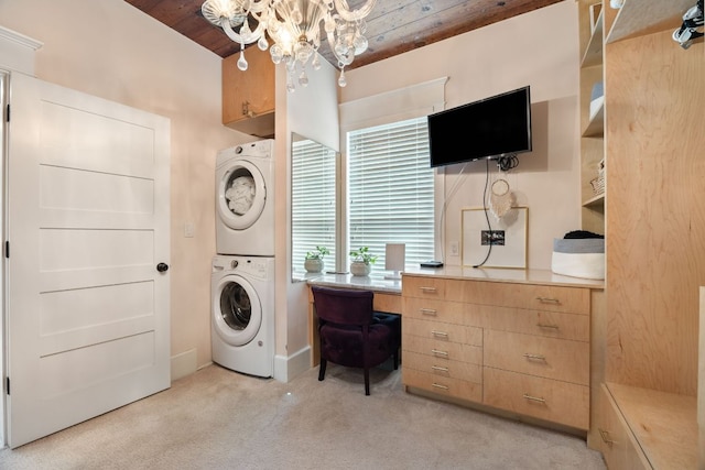 1307 E 2nd St, Austin, TX 78702 - washroom featuring stacked washer / drying machine, a chandelier, light colored carpet, wooden ceiling, and a desk