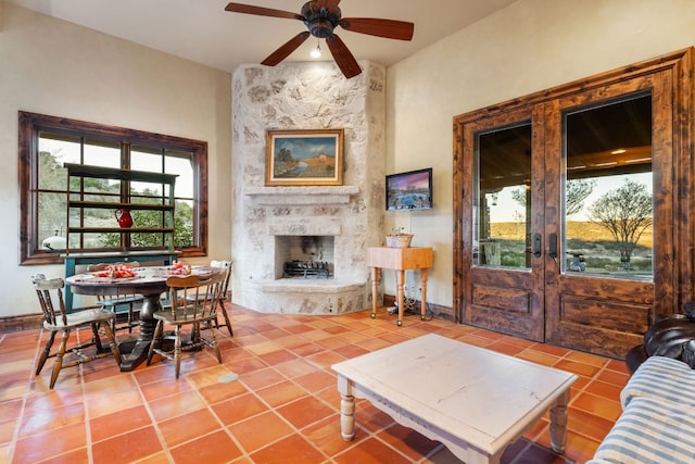 164 Camino Del Reserve, Comfort, TX 78013 - tiled living area featuring french doors, a large fireplace, a ceiling fan, and baseboards