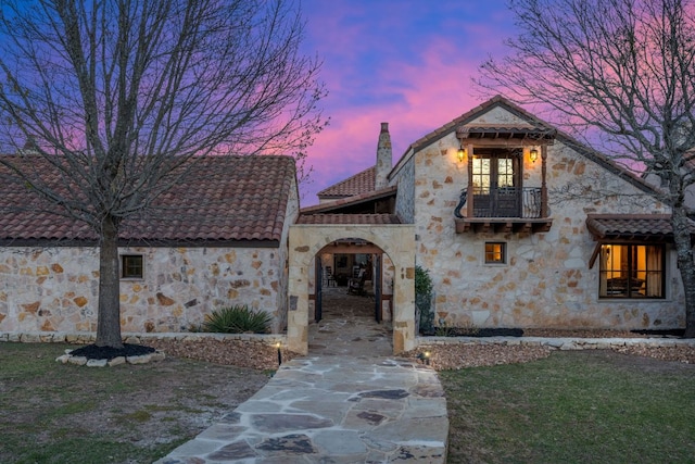 164 Camino Del Reserve, Comfort, TX 78013 - view of front facade with a balcony, a chimney, stone siding, a tiled roof, and a yard