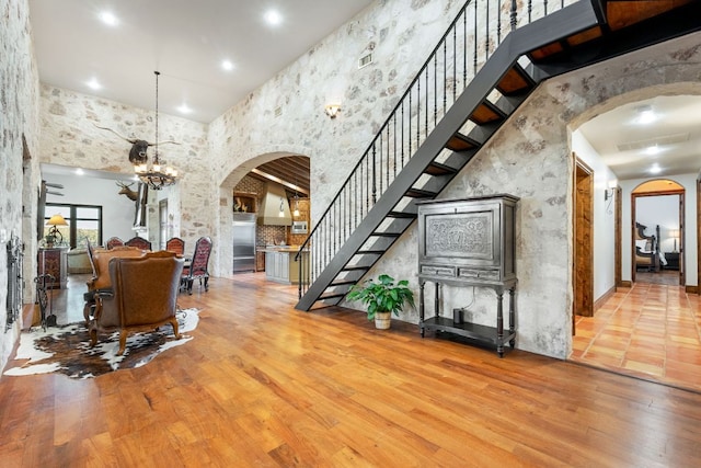 164 Camino Del Reserve, Comfort, TX 78013 - foyer entrance with arched walkways, a chandelier, stairs, wood finished floors, and a high ceiling