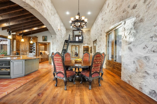 164 Camino Del Reserve, Comfort, TX 78013 - dining area featuring arched walkways, a chandelier, plenty of natural light, beam ceiling, and light wood-style flooring