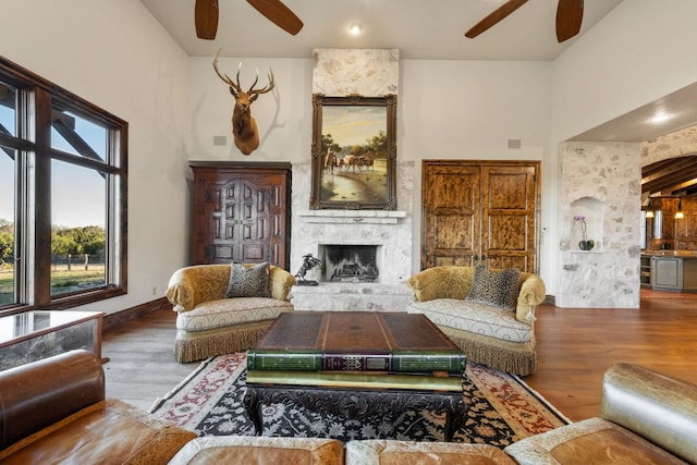 164 Camino Del Reserve, Comfort, TX 78013 - living area featuring a ceiling fan, wood finished floors, a high ceiling, and a large fireplace