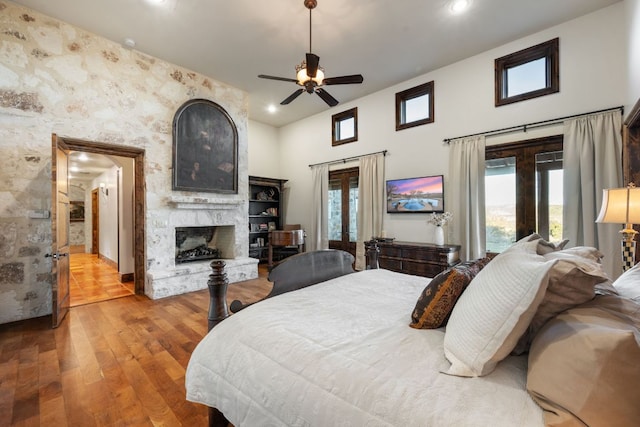 164 Camino Del Reserve, Comfort, TX 78013 - bedroom featuring french doors, wood finished floors, a large fireplace, recessed lighting, and a high ceiling