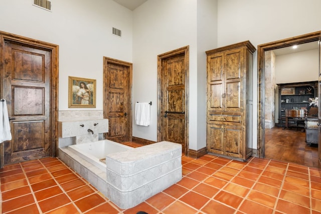 164 Camino Del Reserve, Comfort, TX 78013 - full bathroom with a towering ceiling, a garden tub, tile patterned floors, and baseboards