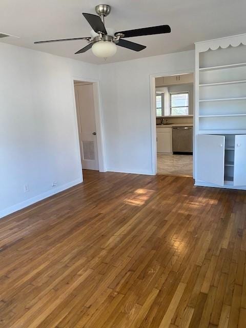 empty room featuring ceiling fan, wood finished floors, and baseboards