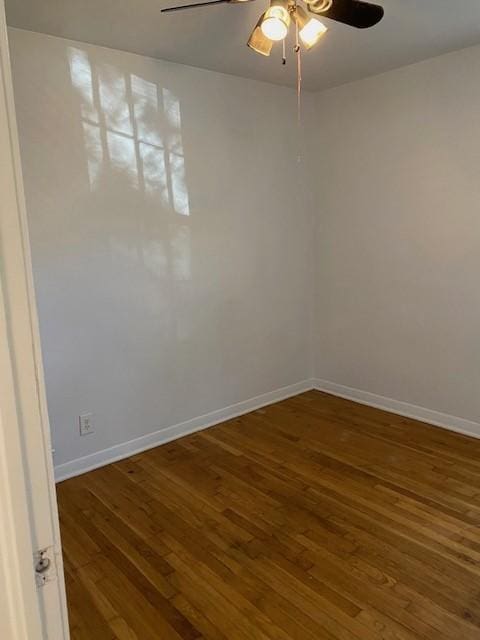 spare room featuring a ceiling fan, wood-type flooring, and baseboards