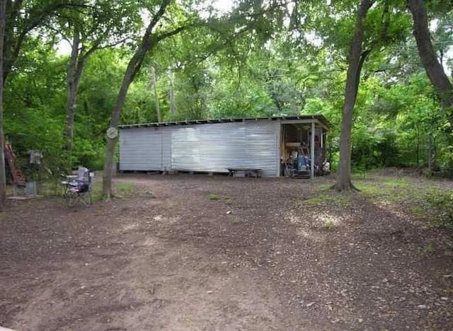 view of outbuilding with an outbuilding and a view of trees