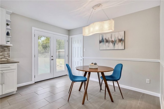 dining space with french doors and baseboards