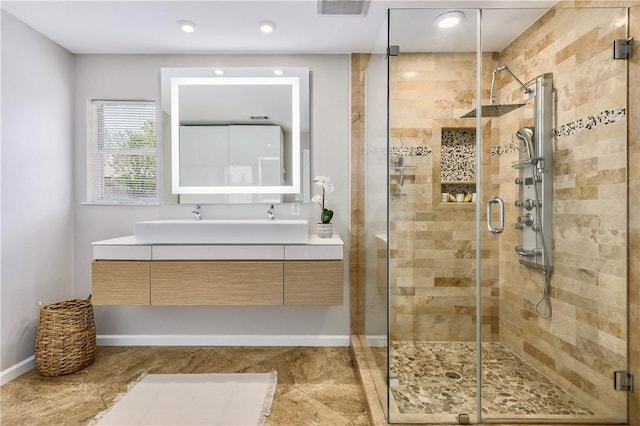 full bath featuring a shower stall, vanity, and baseboards