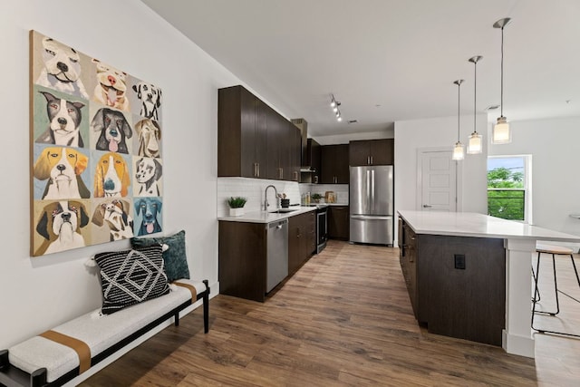 6444 Burnet Rd Unit 204, Austin, TX 78757 - kitchen with appliances with stainless steel finishes, light countertops, dark brown cabinets, and wood finished floors