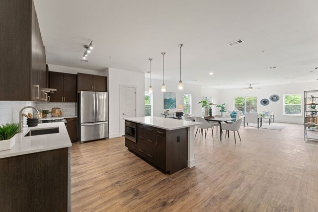 6444 Burnet Rd Unit 204, Austin, TX 78757 - kitchen with stainless steel appliances, dark brown cabinetry, light countertops, and tasteful backsplash