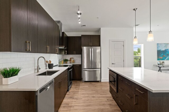 6444 Burnet Rd Unit 204, Austin, TX 78757 - kitchen with appliances with stainless steel finishes, light wood finished floors, decorative backsplash, and light countertops