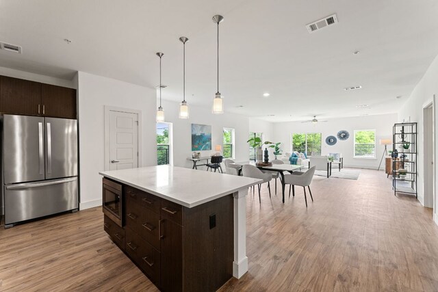 6444 Burnet Rd Unit 204, Austin, TX 78757 - kitchen featuring appliances with stainless steel finishes, wood finished floors, dark brown cabinets, and open floor plan